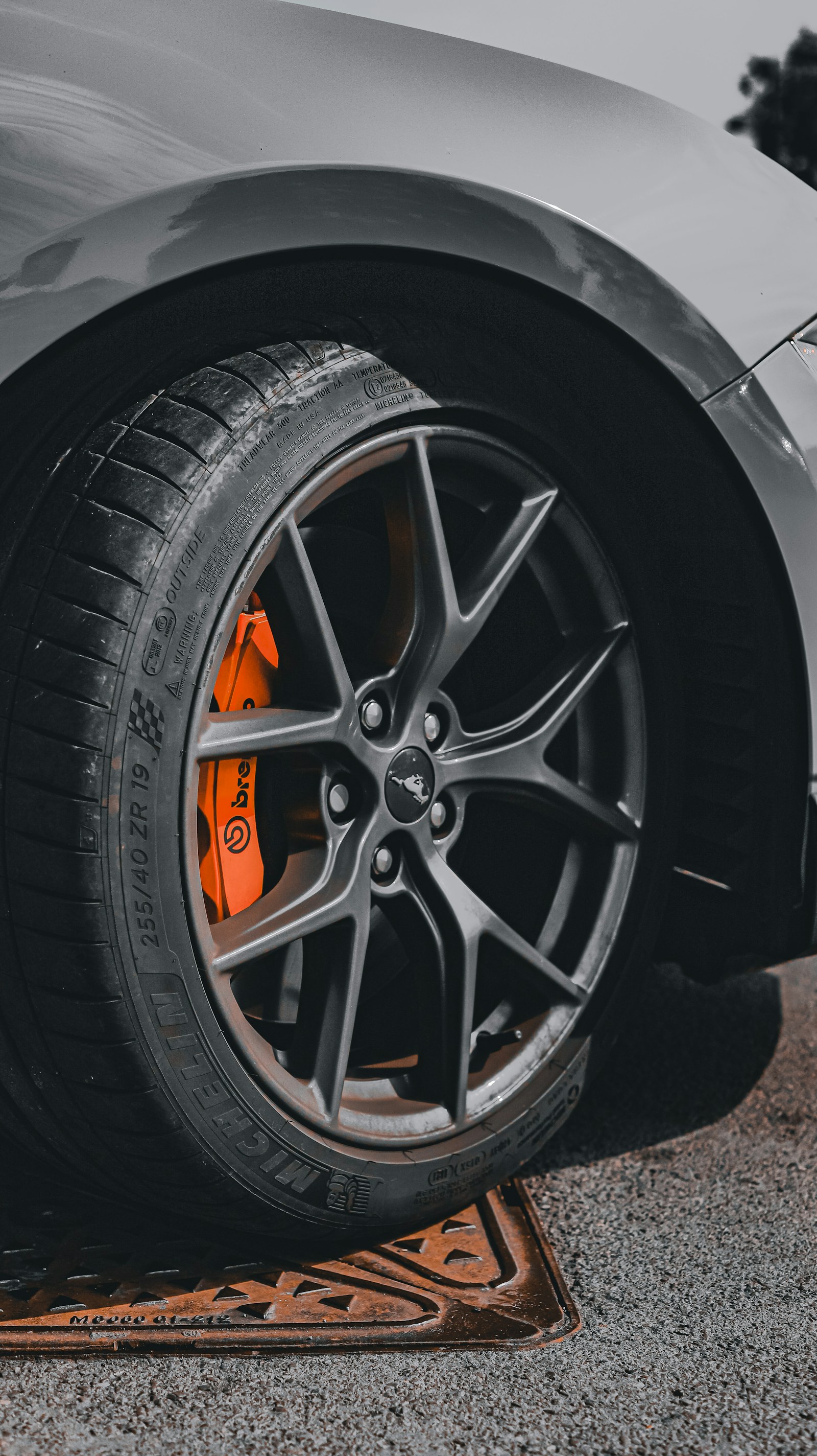 Alloy wheel, tire, and brake hardware photographed in a workshop
