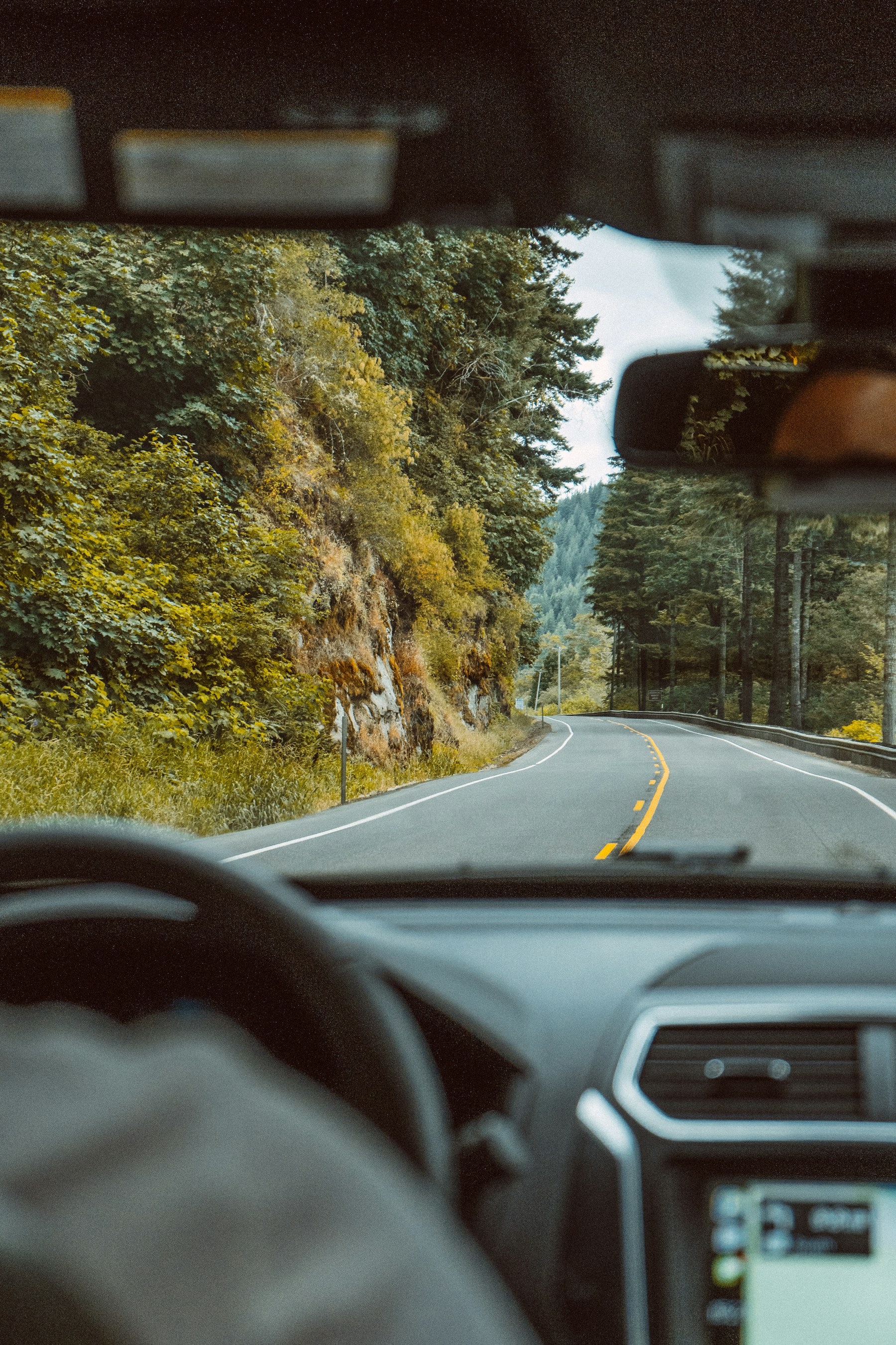 View through a car windscreen toward a quiet road