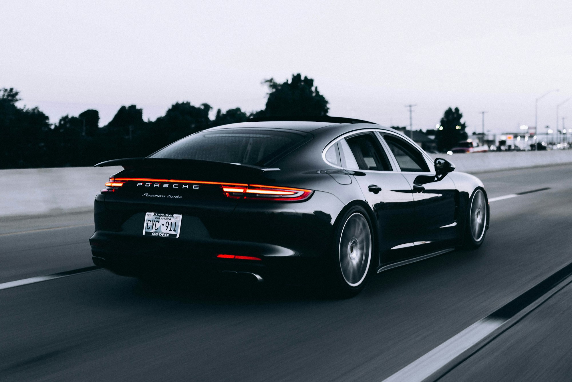 A dark coupe seen low and close on an open road